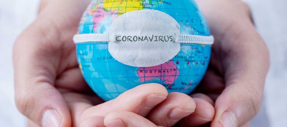 person holding miniature world globe