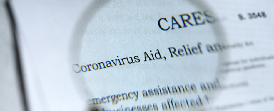 maginifying glass views coronavirus aid on paper
