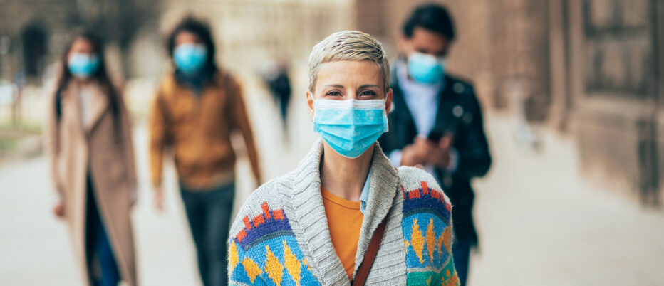 short haired girl walks toward the camera wearing face mask