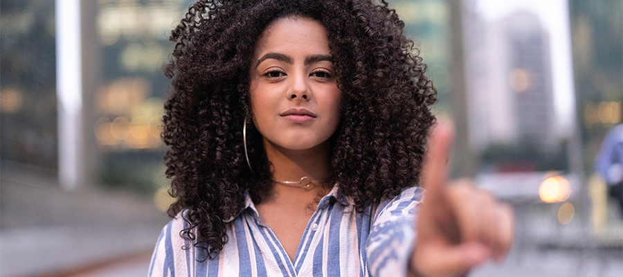 Image of African American woman confidently holding up pointer finger.