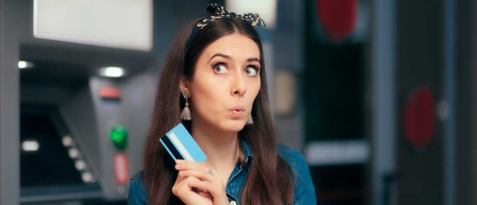 young adult girl looks up and holds credit card