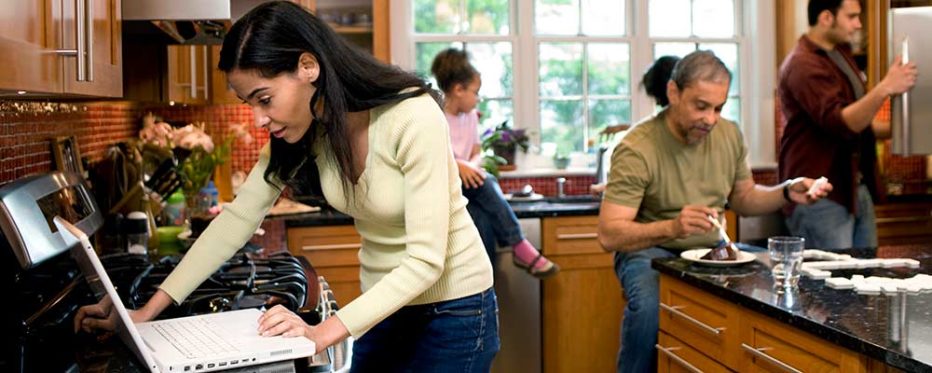 woman working from home surrounded by family members distracting her